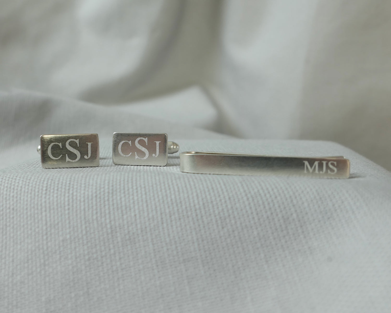 Silver tie bar and cufflink set with logo